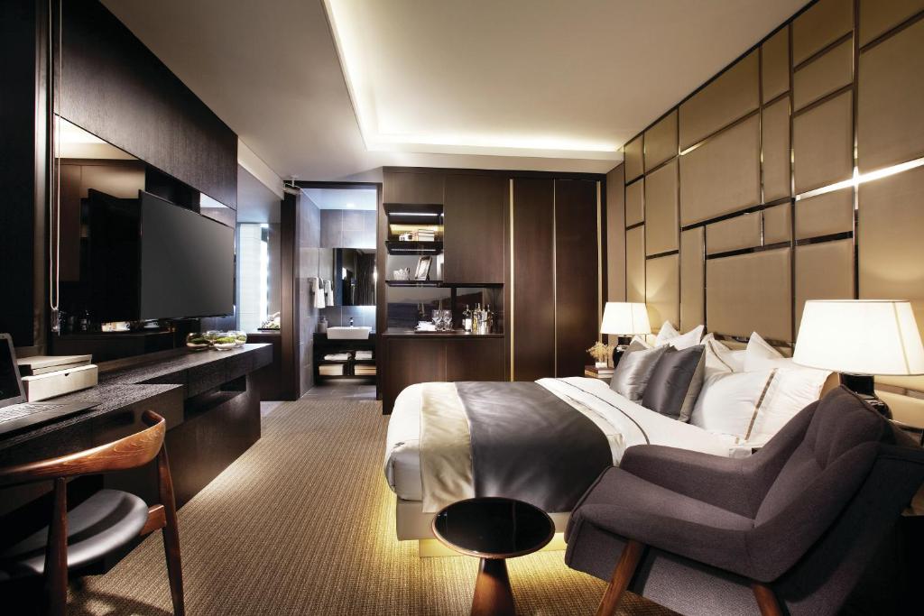 a hotel room with a bed and a chair and a television at Royal Emporium Incheon Airport in Incheon