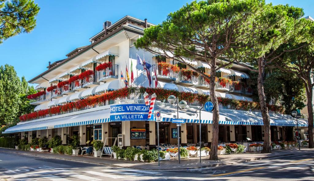 a large building with flags on the side of it at Hotel Venezia e la Villetta in Lido di Jesolo