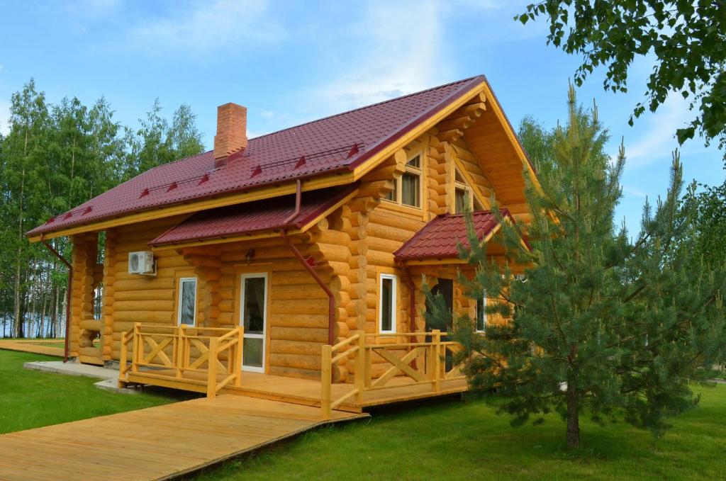 a log cabin with a deck and a house at Woods Lake Resort in Potashëvo