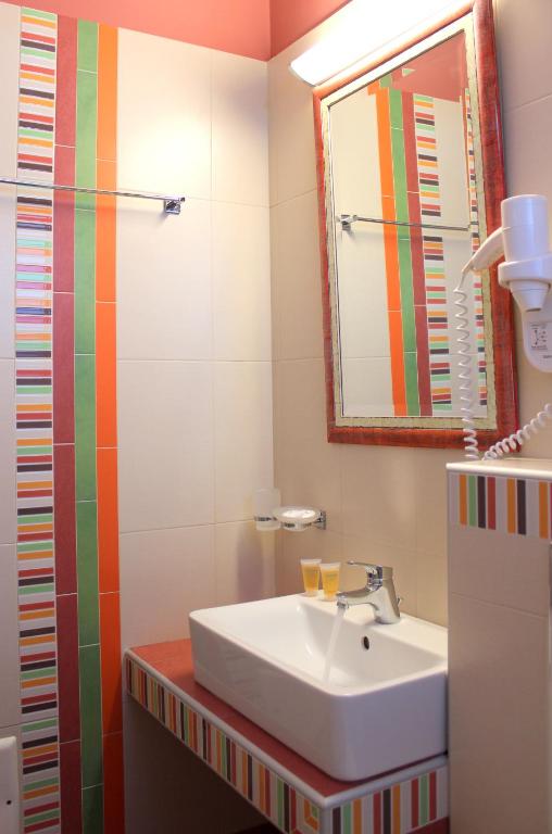 a bathroom with a sink and a mirror at Amaryllis Hotel Apartments in Tolo