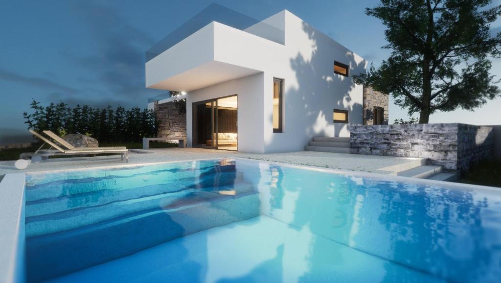 a villa with a swimming pool in front of a house at Iskios Villas in Agia Marina Nea Kydonias