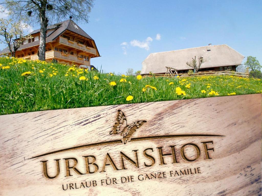 zwei Schmetterlinge auf einem Schild auf einem Blumenfeld in der Unterkunft Urbanshof Ferienwohnungen in Hinterzarten