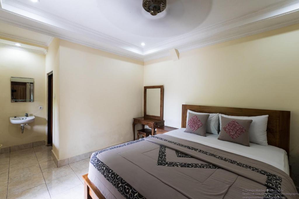 a bedroom with a large bed and a bathroom at Sudiana House in Ubud