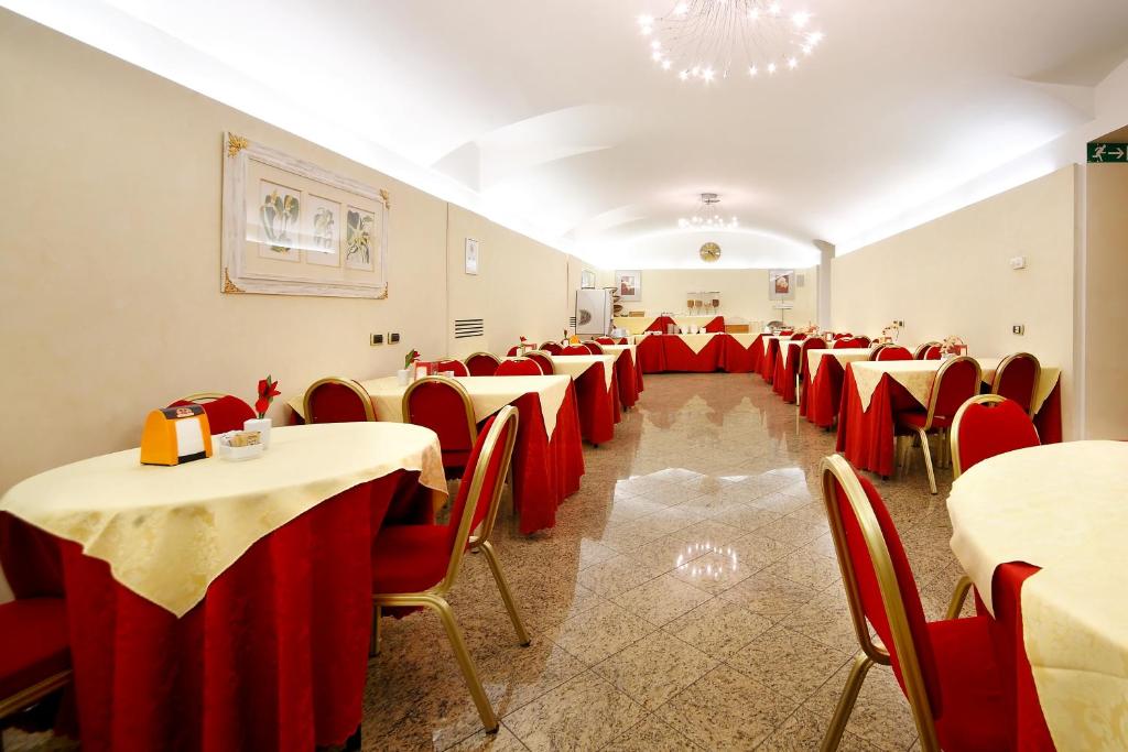 a room with tables and chairs with red table cloths at Hotel Terminal in Milan