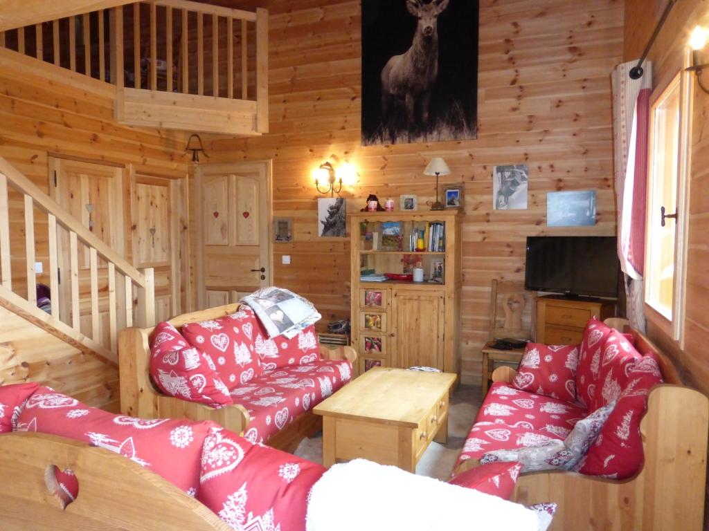 EnchastrayesにあるChalet Le Villardの赤い家具付きのリビングルームが備わるキャビンです。