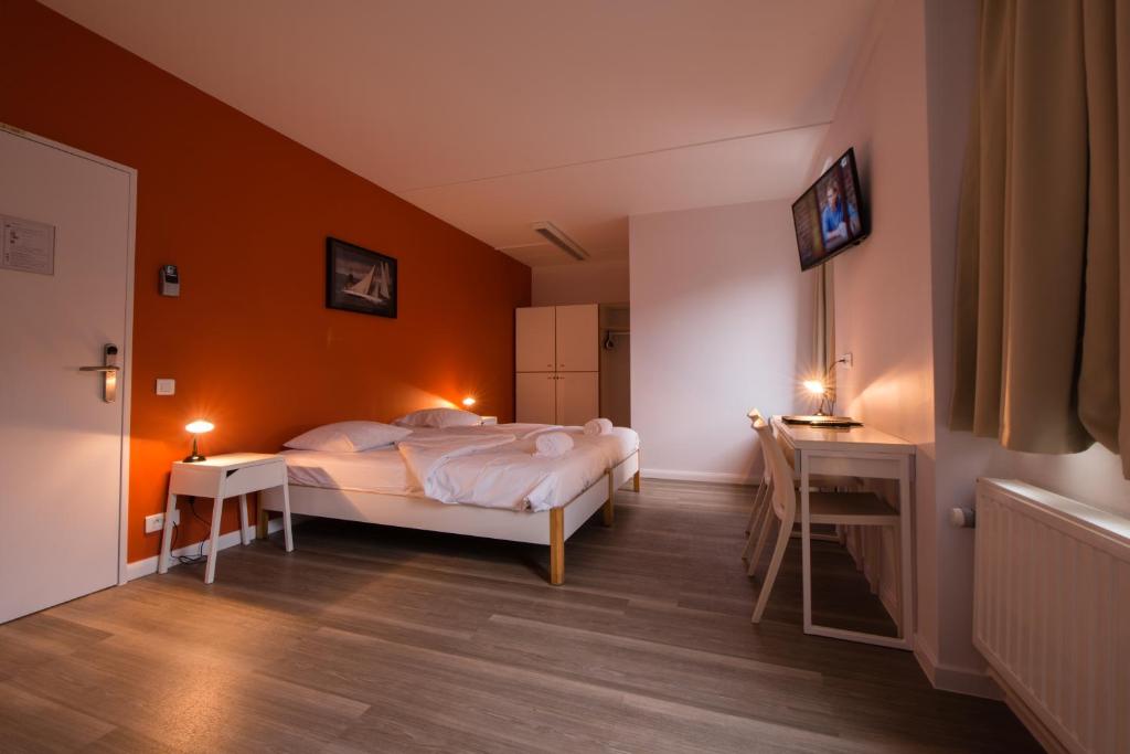 ブリュッセルにあるオーベルジュ デ 3 フォンテーヌのベッドルーム1室(オレンジ色の壁のベッド1台付)