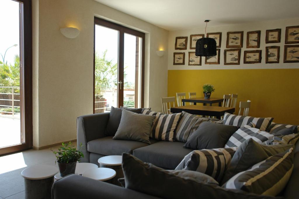uma sala de estar com sofás e mesas e uma mesa em Sapore di Mare em Porto Empedocle