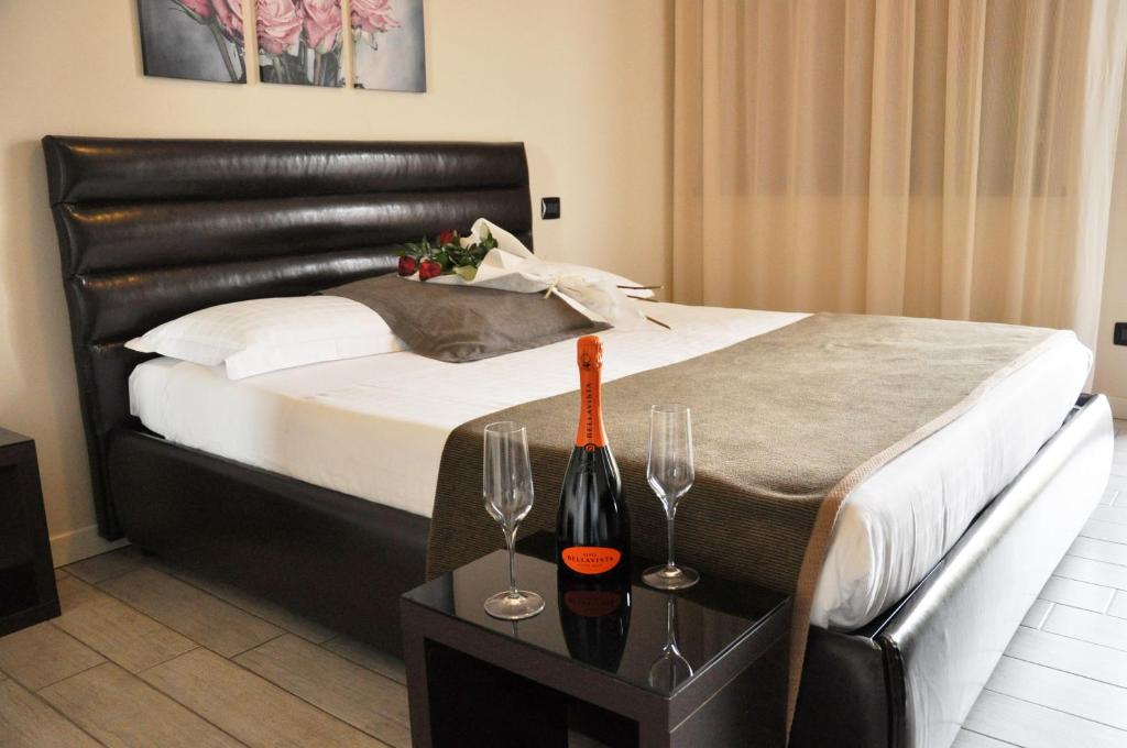 Schlafzimmer mit einem Bett mit Weingläsern auf dem Tisch in der Unterkunft Rimmel Motel in Parma
