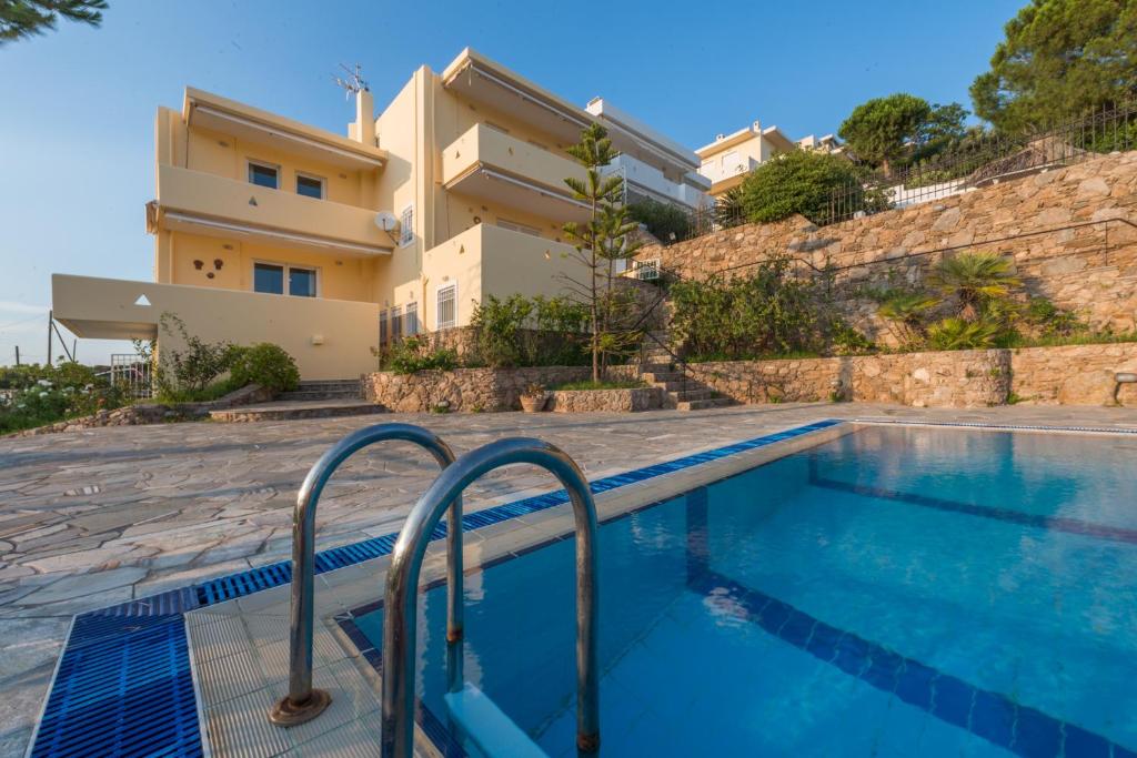 a swimming pool in front of a house at Villa Adamite in Sounio
