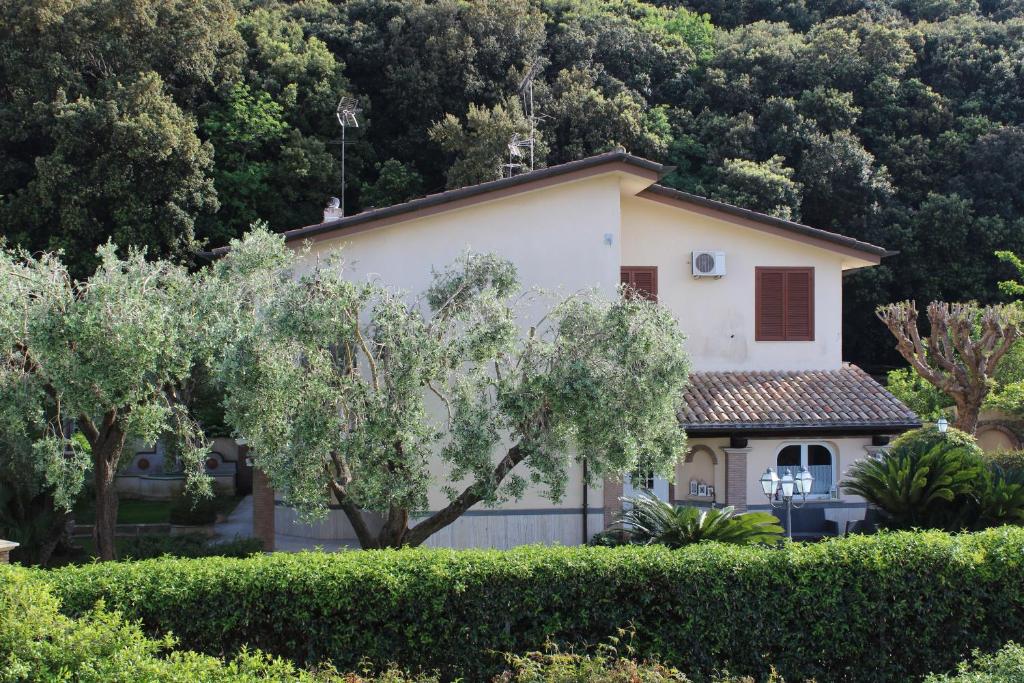 a house in front of a mountain with trees at B&B Cavalieri in San Felice Circeo