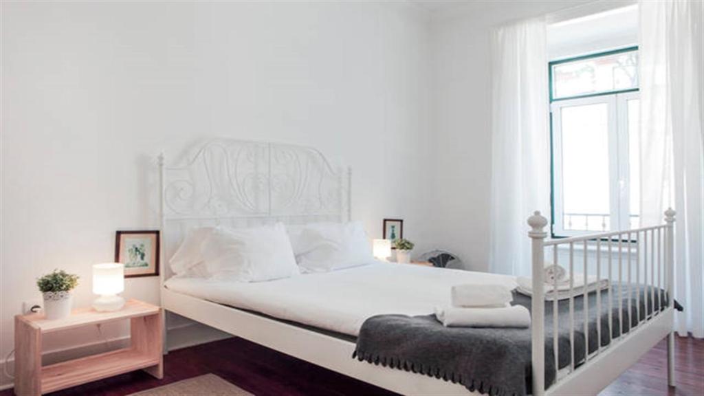リスボンにあるSpacious Tailor Made Bairro Altoの白いベッドルーム(白いベッド1台、窓付)