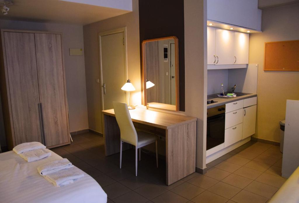 małą kuchnię z biurkiem i łóżkiem w pokoju w obiekcie City Apartments Antwerpen w Antwerpii
