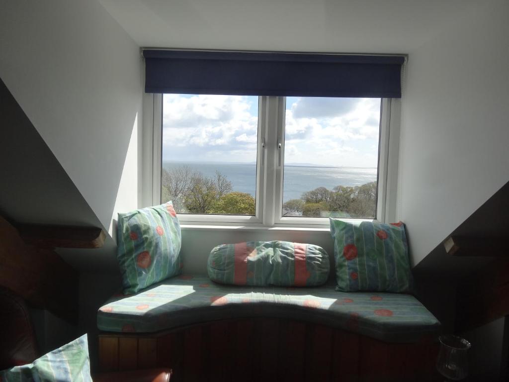 a couch sitting in front of a large window at Claremont House in Saundersfoot