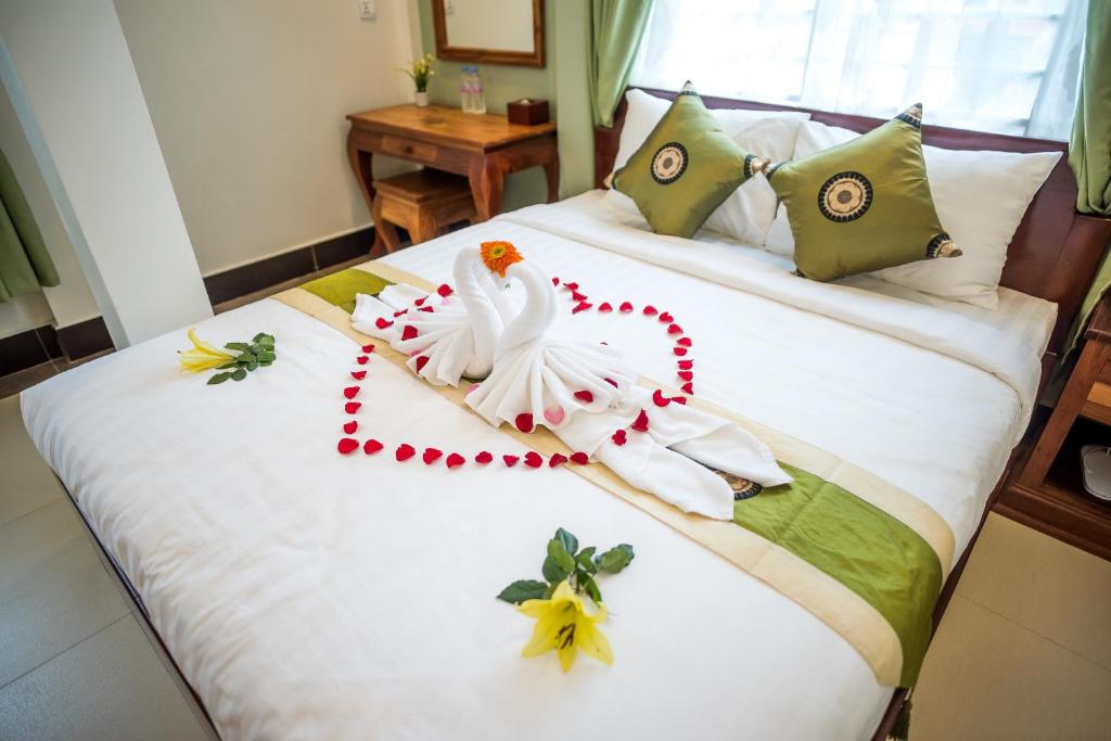 un dormitorio con una cama con una decoración de cisne en NKS Hotel, en Phnom Penh