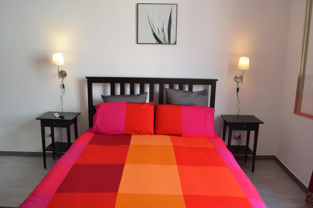 キアラモンテ・グルフィにあるAkrillhouse Locazione Turisticaのベッドルーム1室(カラフルなベッド1台、テーブル2台付)