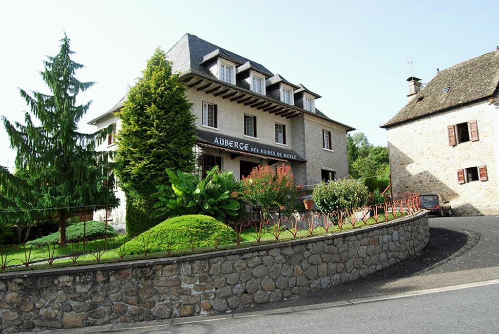 eine Steinmauer vor einem Gebäude in der Unterkunft Auberge des Ruines de Merle in Saint-Cirgues-la-Loutre