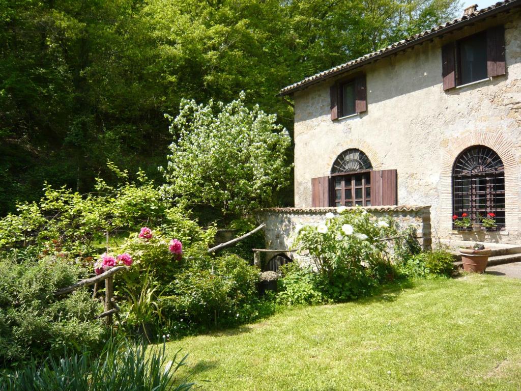 a garden in front of a building with flowers at Agriturismo biologico il Molinaccio al Rio Chiaro in Civitella dʼAgliano