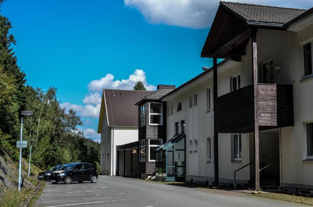 a car parked on a street next to some buildings at Hotel & Tagungszentrum Hessenkopf in Goslar