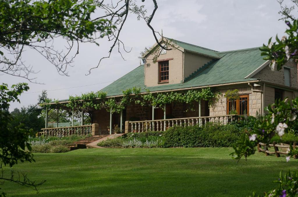 een huis met een groen dak en een tuin bij Halliwell Country Inn in Howick