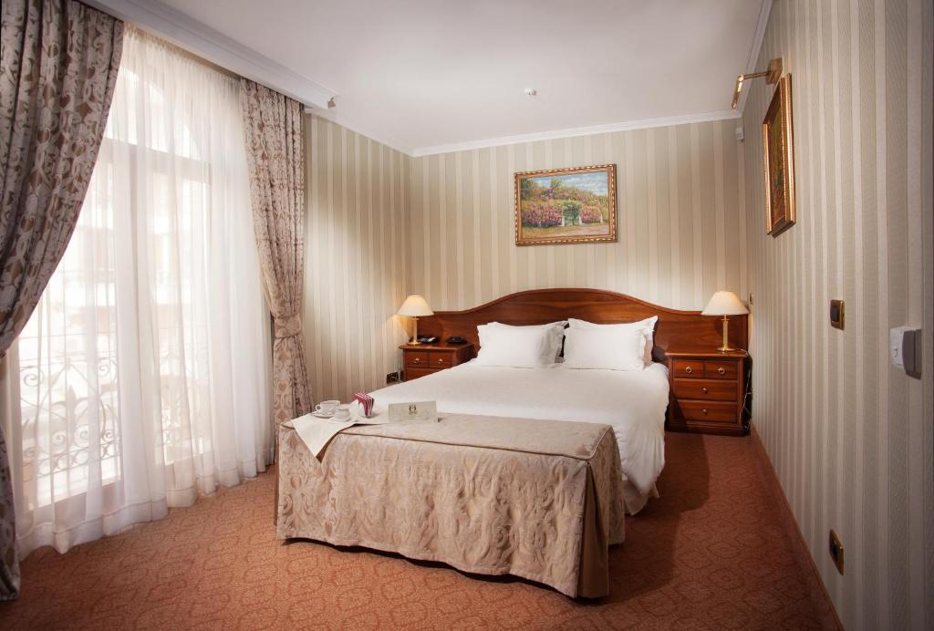 a bedroom with a bed and a dresser at Hotel Otrada in Odesa