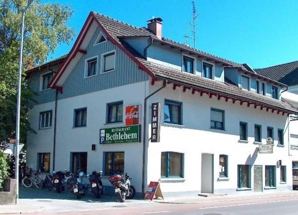 a large white building with motorcycles parked in front of it at Gasthaus Bethlehem in Dornbirn