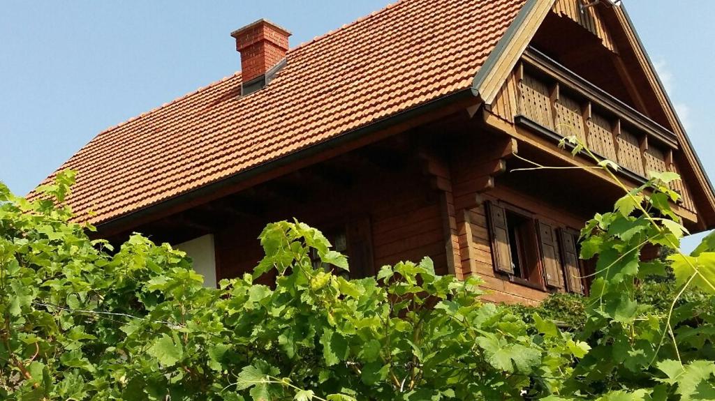 una casa con techo de tejas y algunos árboles en Kellerstöckl am Rosenberg, en Straden