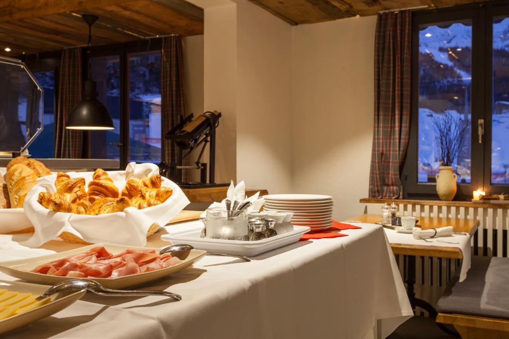 a table with a plate of food on it at Hotel THE LARIX ski-in ski-out in Saas-Fee