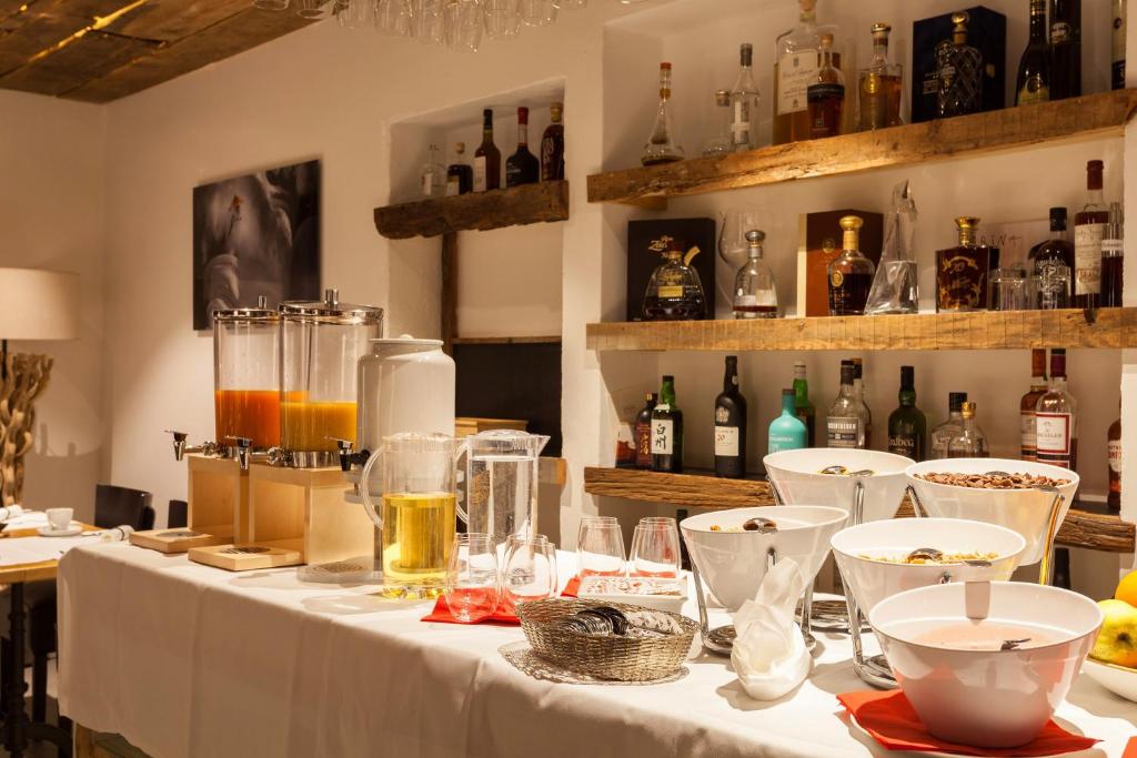 a table with a white table cloth and bottles of alcohol at Hotel THE LARIX ski-in ski-out in Saas-Fee