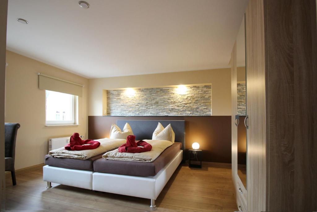 ワイマールにあるアパートメンツ ルーストラスのベッドルーム1室(赤い枕のベッド1台付)