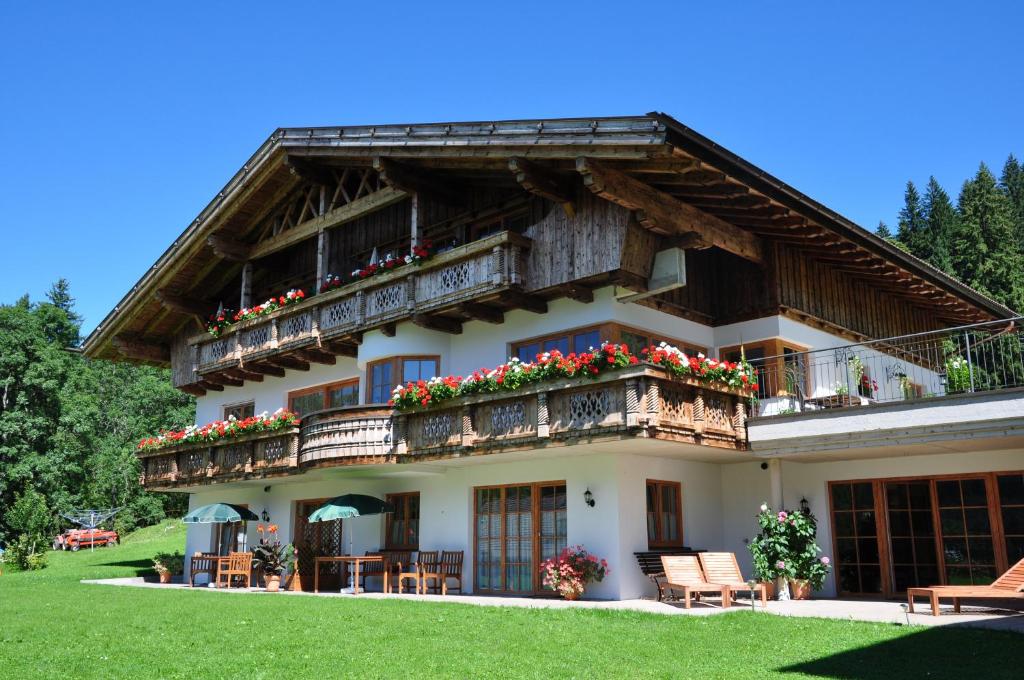 a building with a balcony with flowers on it at Landhaus Alpensonne in Schattwald