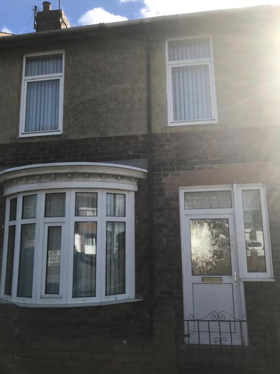 a brick house with a white door and windows at Longfield Road in Darlington