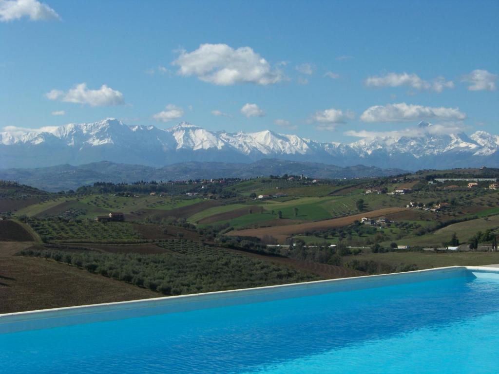 uitzicht op een zwembad met bergen op de achtergrond bij Casa Cologna Appartementen in Roseto degli Abruzzi