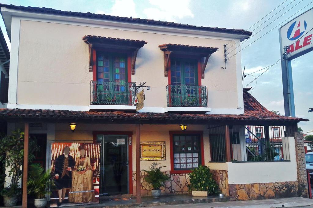 un edificio blanco con 2 balcones en una calle en Pousada Vila Inconfidentes - Centro Historico, en Tiradentes
