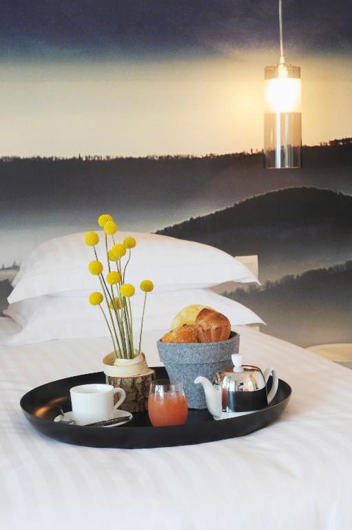 a plate of food with bread and coffee on a bed at L’Échappée Belle in LʼIsle-Jourdain