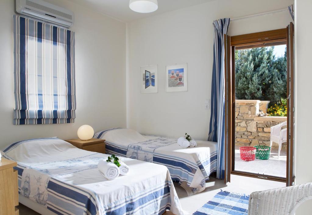 sypialnia z 2 łóżkami i patio z oknem w obiekcie Natica Mare Villas w mieście Xerokampos