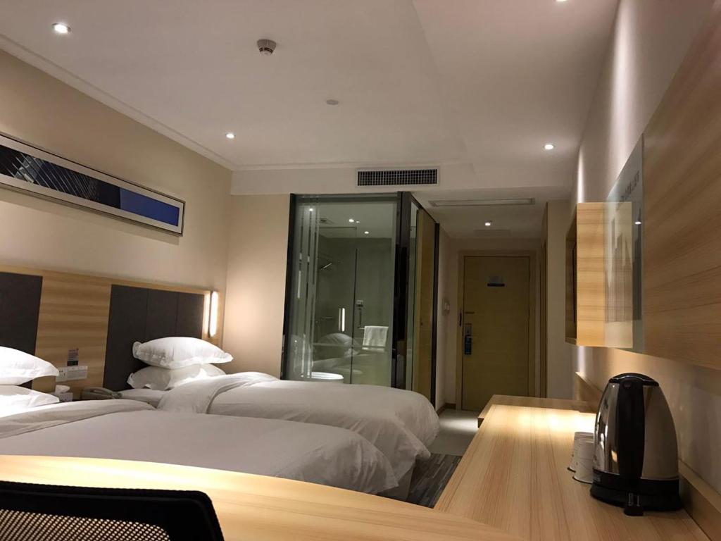 Postel nebo postele na pokoji v ubytování Hotel Pomelo Premier 西柚臻选武昌站酒店
