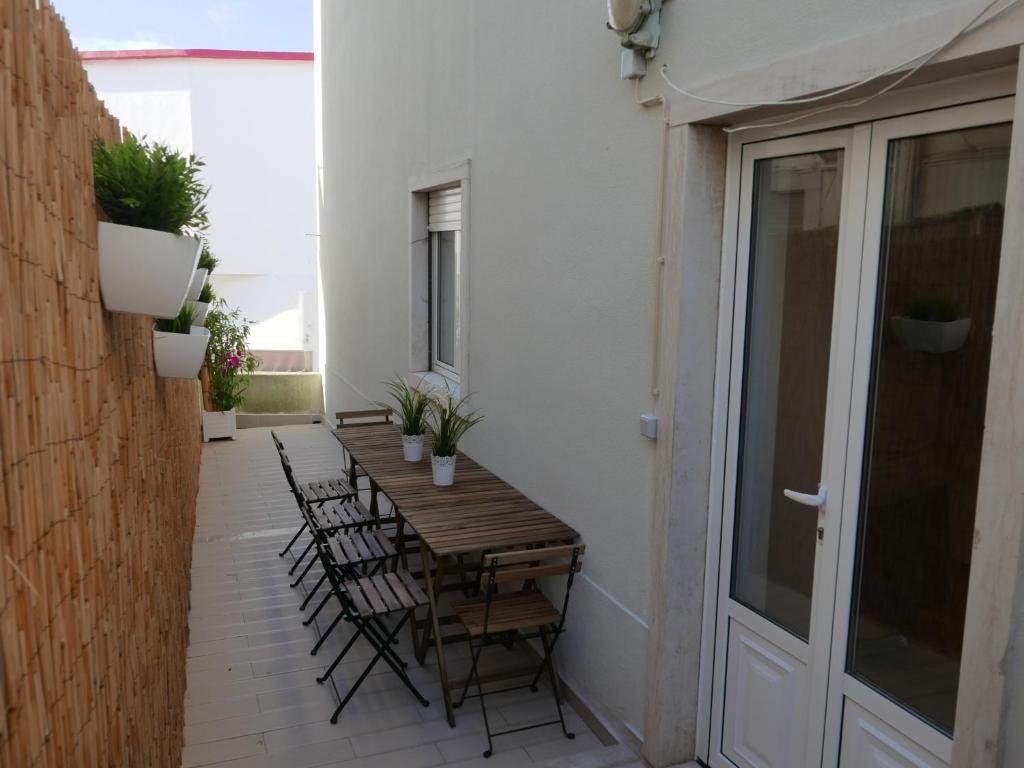 un patio con mesa de madera y sillas en Casa do Cabeta, en Nazaré