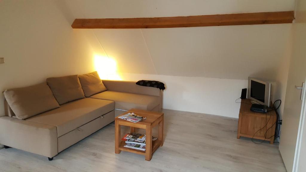 a living room with a couch and a table at Vakantiehuis Limburg - Landgraaf in Landgraaf