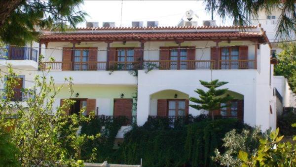 a white house with a balcony on top of it at Litsa Studios in Patitiri