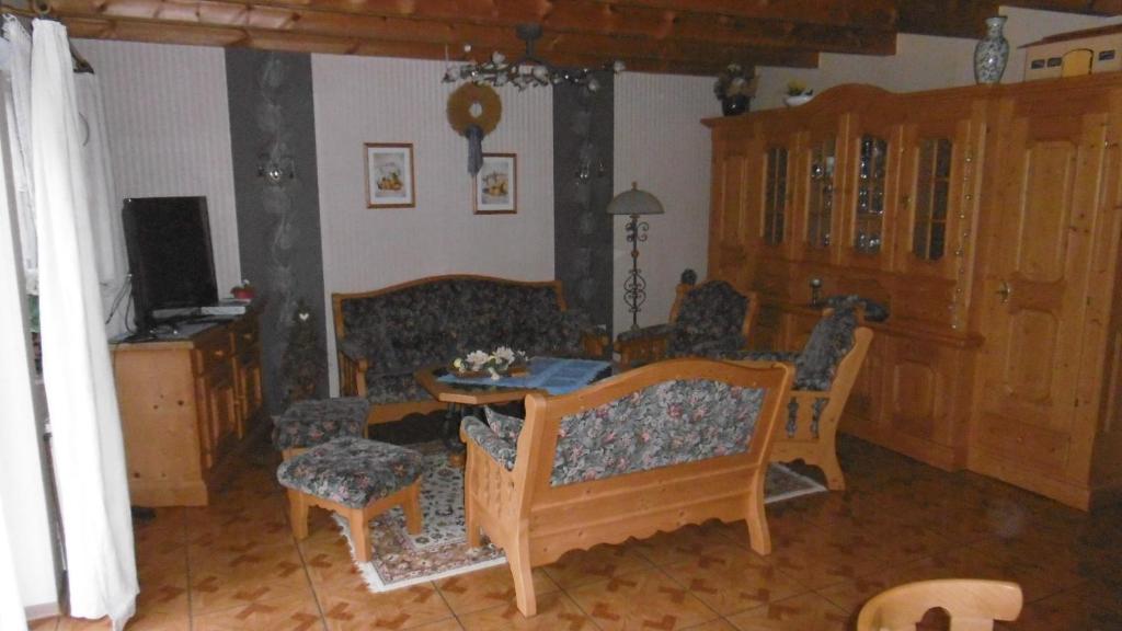 sala de estar con sofá, mesa y sillas en Spargelhof, en Sudwalde