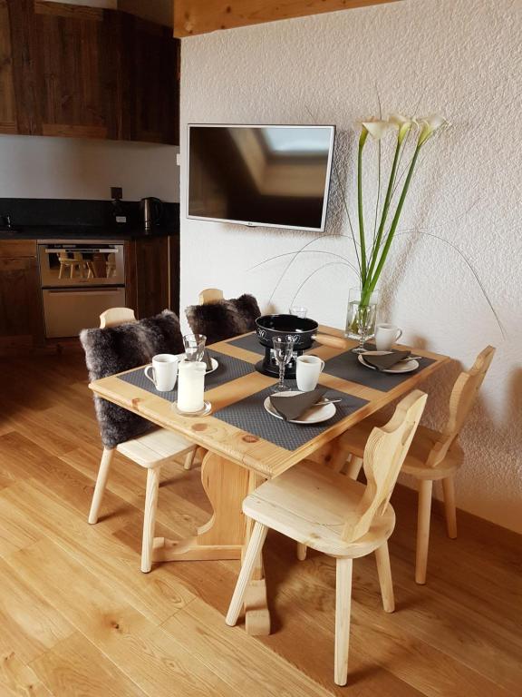 einen Holztisch und Stühle in der Küche in der Unterkunft Studio 166 Le Bristol Villars in Villars-sur-Ollon