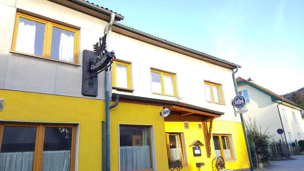un edificio blanco y amarillo en una calle en Gasthaus Schwarzer Adler en Altenberg
