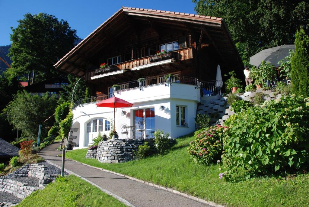 una casa en una colina con un paraguas rojo en Jobin Brienz, en Brienz