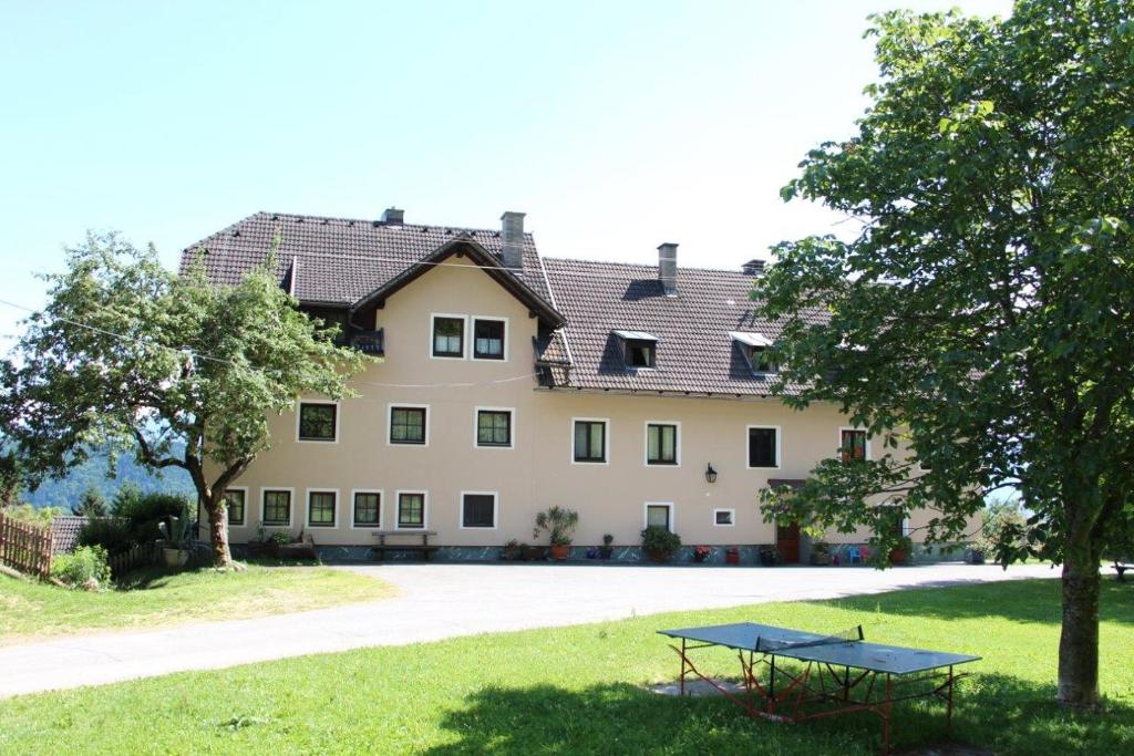 ein großes Haus mit einem Tisch davor in der Unterkunft Bauernhof Landhaus Hofer in Annenheim