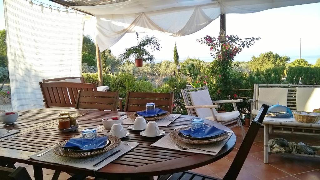 een houten tafel met blauwe servetten en borden erop bij Arcamyrtus in Alghero