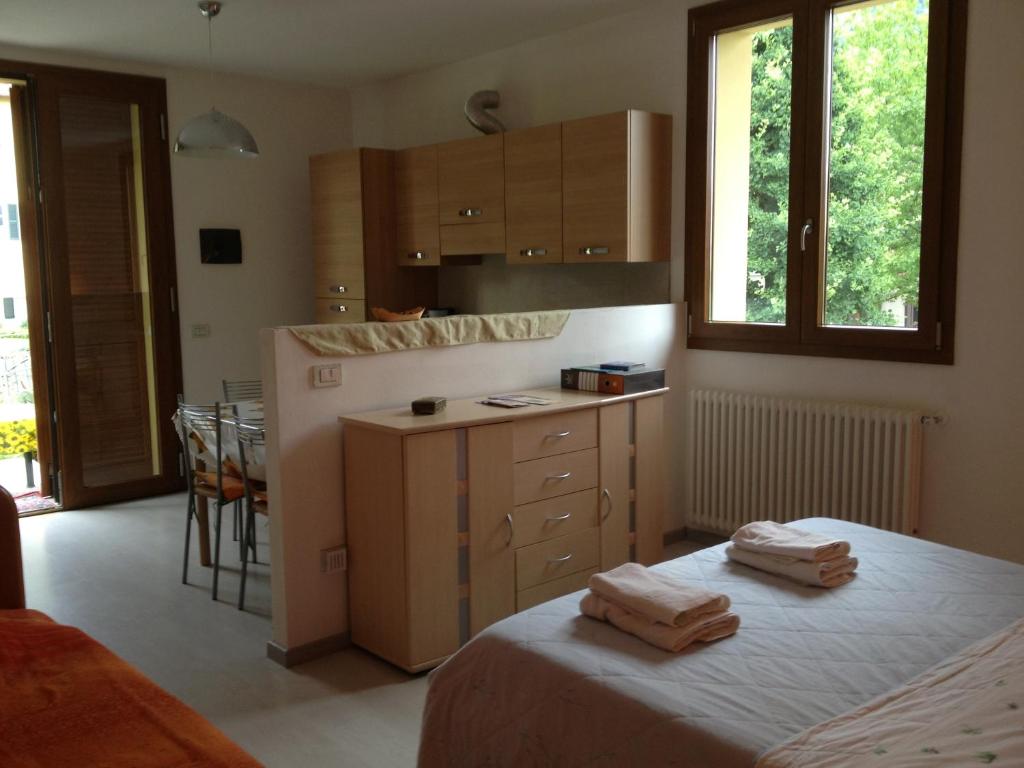 una cucina con letto e bancone con asciugamani di Casa Pini a Griante Cadenabbia