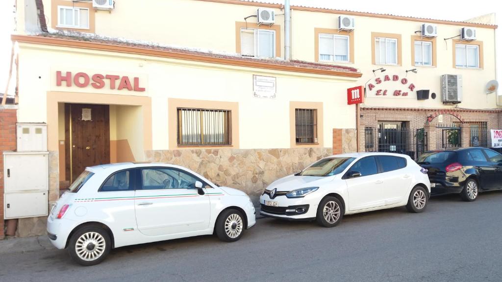 dois carros brancos estacionados em frente a um hotel em Hostal Seseña em Seseña