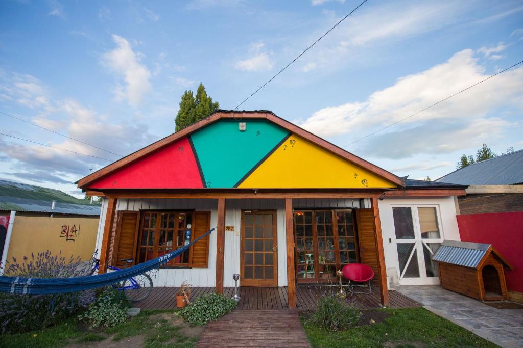 uma casa colorida com uma rede em frente em Bla Guest House em El Calafate