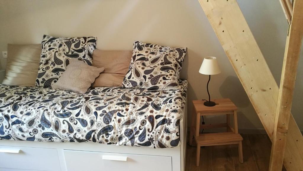 a bed in a room with a lamp on a table at La petite maison in Sisteron