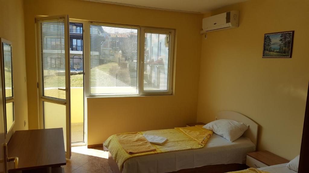 1 dormitorio con cama y ventana en Villa Krisia Apartments, en Sozopol